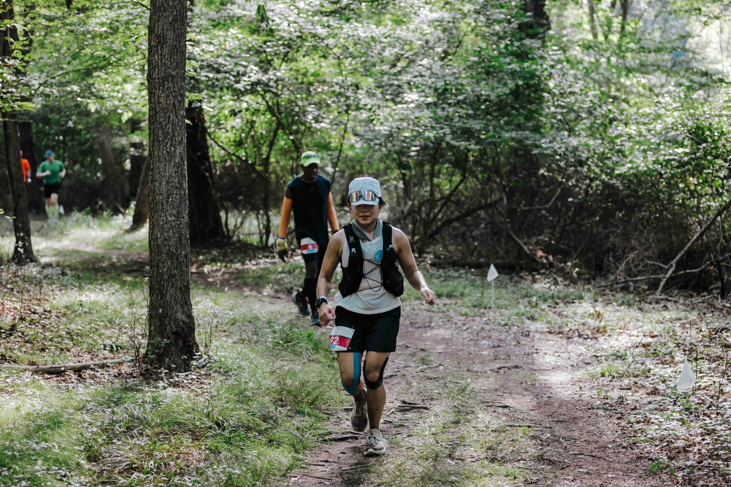 Runner navigating a wooded trail section of the Anchor Down Ultra Marathon course.