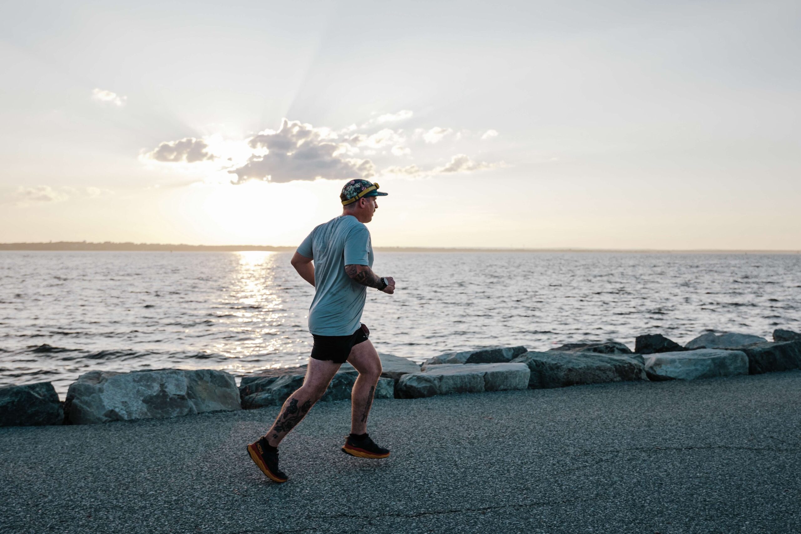 Solo runner silhouette against the sunrise on the Anchor Down Ultra Marathon waterfront course.