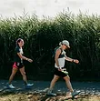 Pacers running alongside participants through tall grass during the Anchor Down Ultra Marathon.