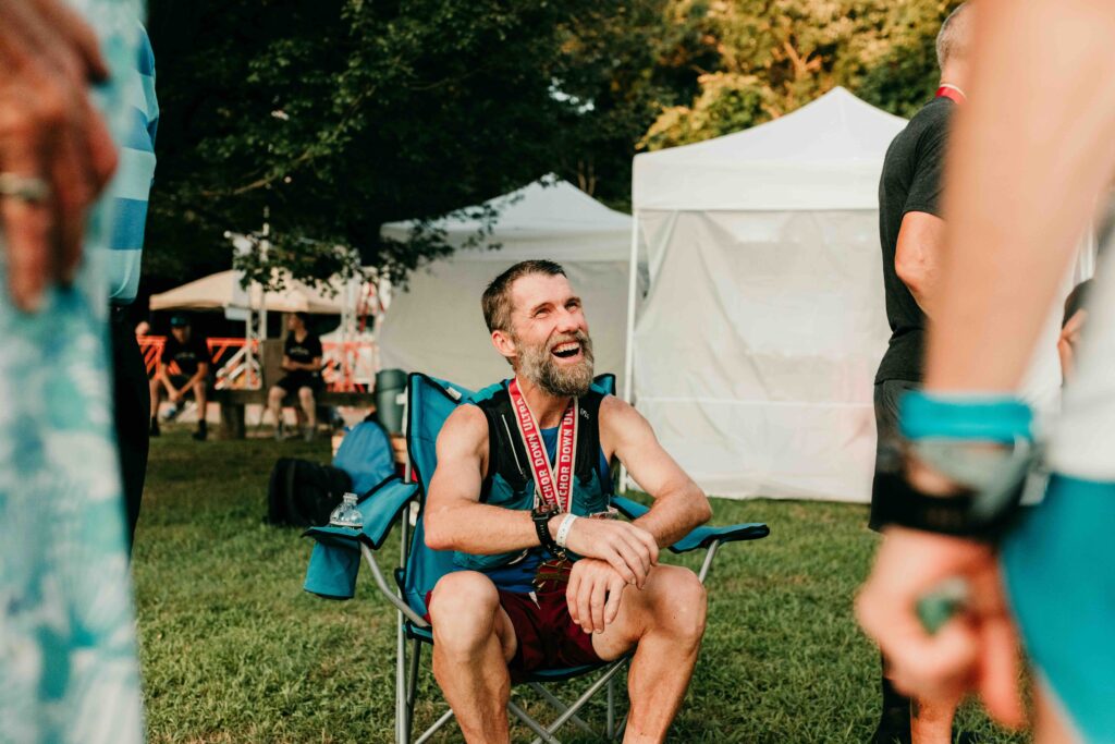 Runners enjoying a moment of camaraderie in the camping area adhering to the 'On-Site Rule' during the Anchor Down Ultra Marathon.