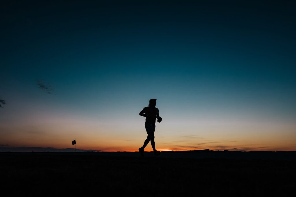 Silhouette of a lone runner against a twilight sky, symbolizing the determination and endurance of athletes at the Anchor Down Ultra Marathon.